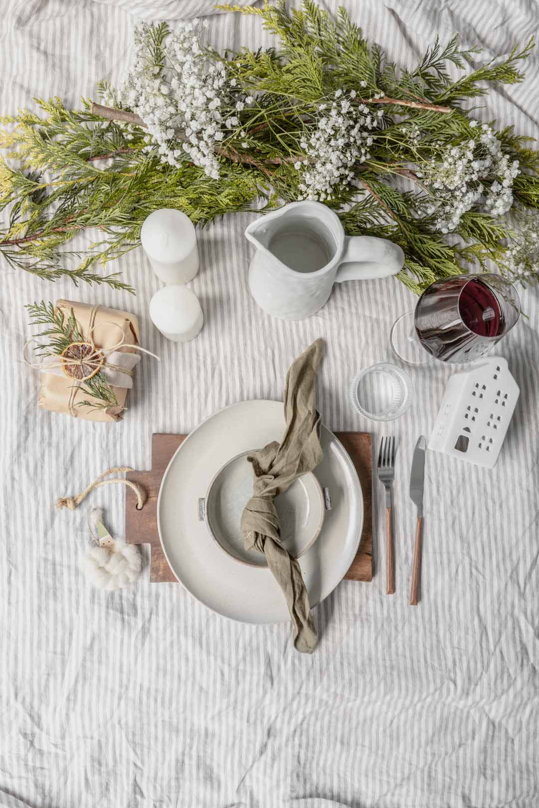 A cottagecore farmhouse inspired table setting for your Christmas lunch or dinner how to se your table for Christmas using natural elements and brown paper wrapped gift