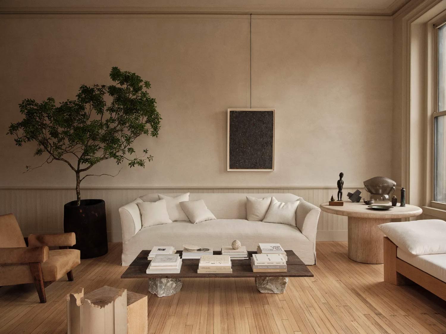 A wabi sabi inspired living room featuring textured walls and minimal colour palette and an indoor tree