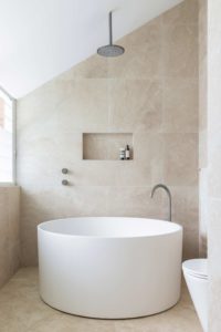 Modern bathroom with brushed nickel tapware and round bath using basic interior design principles of balance harmony proportion and rhythm