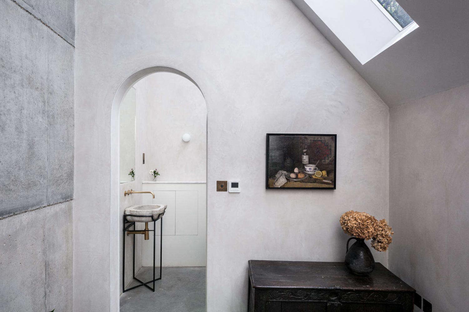 minimalist wabi sabi interior design a simple bathroom with a stone basin brass tapware and heavy timber furniture